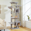 Tall grey cat tree beside a sunny window, white tabby on an upper platform and orange tabbies in hammock and base condo