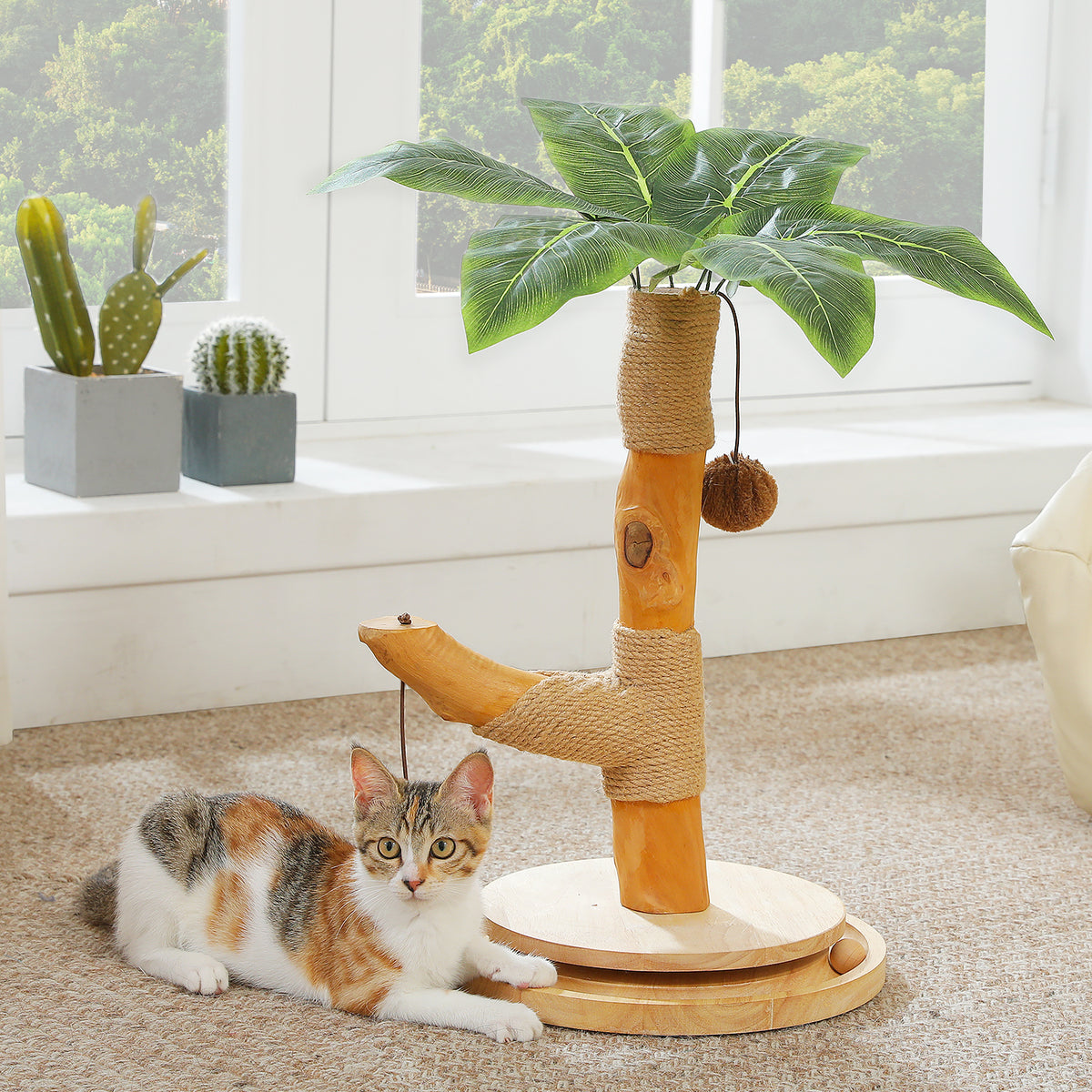 Palm-tree cat scratching post 45cm with sisal-wrapped trunk, green leaves and ball track, calico kitten nearby