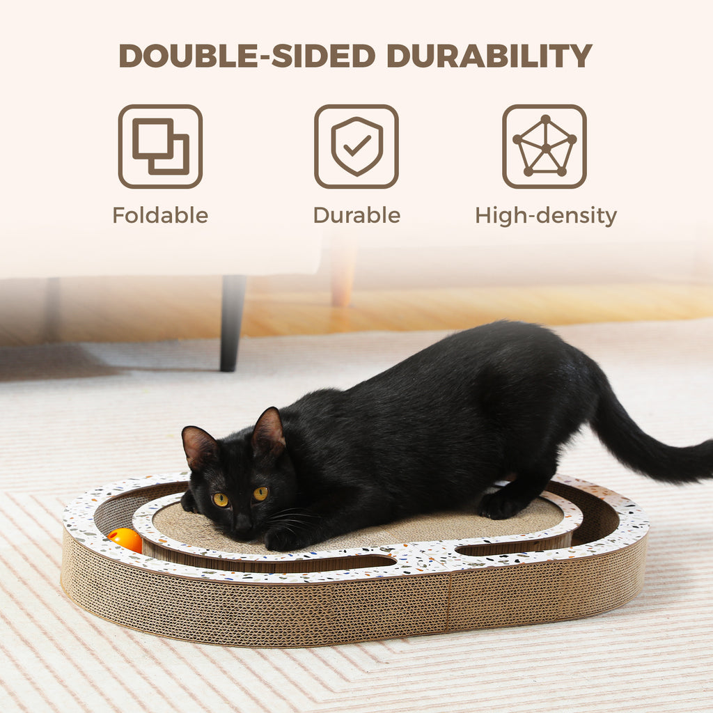 Black cat crouched on the cardboard scratcher pawing an orange track ball beneath a Double-Sided Durability banner