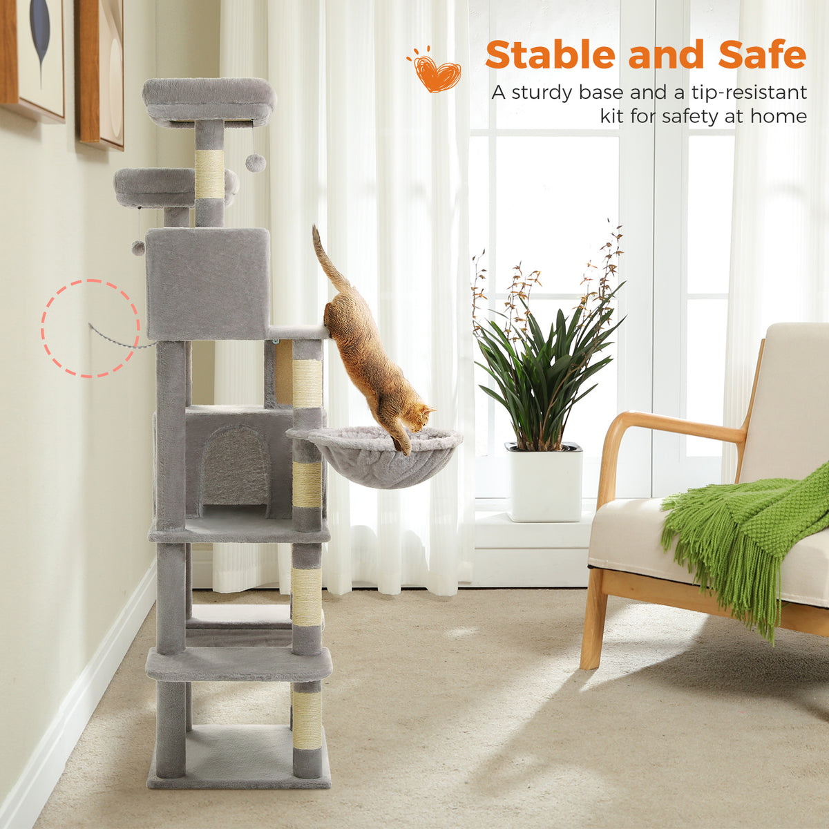 Orange tabby leaping into a plush hammock while a wall anchor strap on the tree shows the tip-resistant safety kit