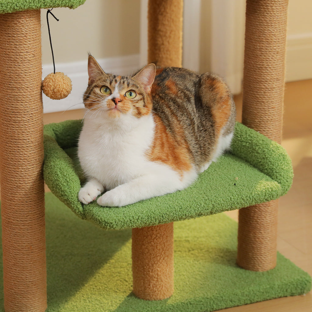 Calico tabby cat lounging close-up on the green curved platform of the 110cm cat tree