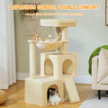 Beige plush cat tree with twin arched condos and a hanging hammock in a green living room, ginger cat napping inside