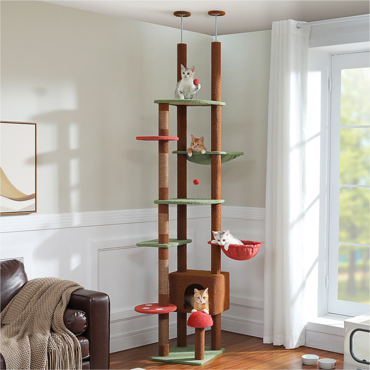 Brown and green floor-to-ceiling cat tree with red mushroom perches and four kittens playing at different levels